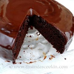 A close up photo of deep dark chocolate cake with a slice taken out.