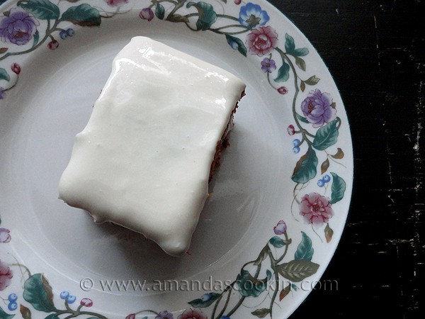 An overhead photo of a square of low fat carrot cake on a decorative plate.