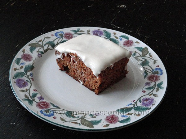 A photo of a square of low fat carrot cake on a decorative plate.