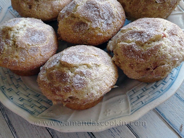 A close up photo of sugar crusted plum muffins on a plate.