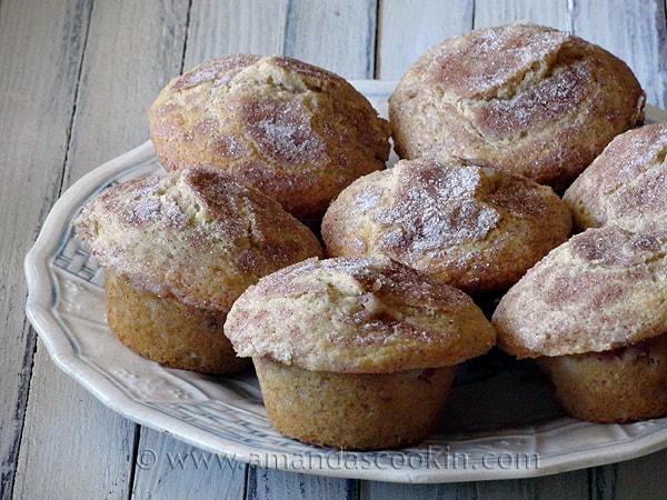 A photo of sugar crusted plum muffins on a plate.