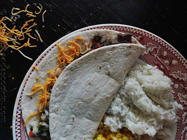 An overhead photo of a steak soft taco resting on a plate.