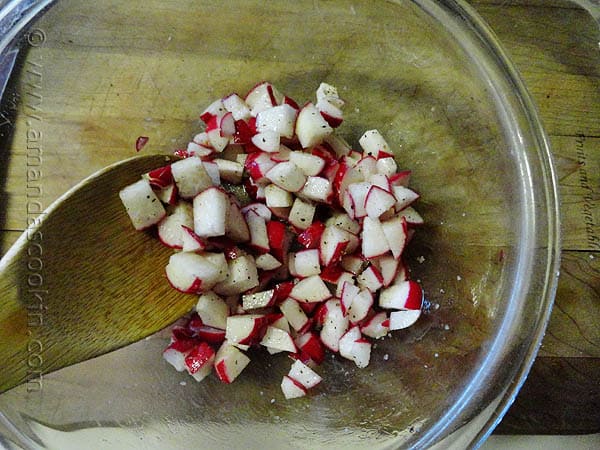 A close up photo of chopped radish in a clear bowl.