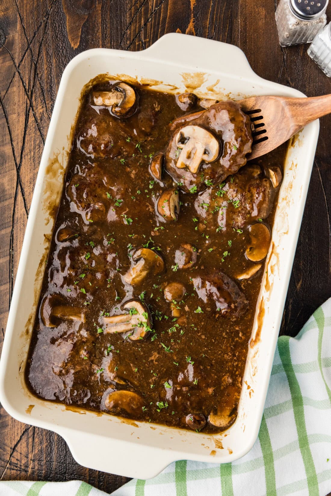 Baking dish of Salisbury Steaks with a spatula in it