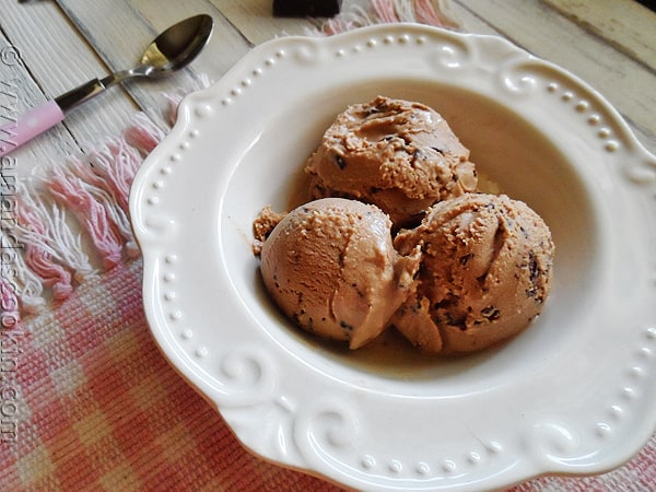 An overhead photo of three scoops of mocha chocolate chip ice cream in a white bowl.