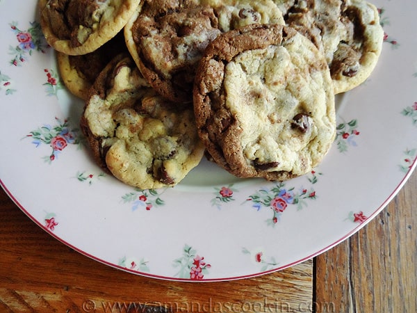 A close up photo of a plate of half and half chocolate chip cookies.