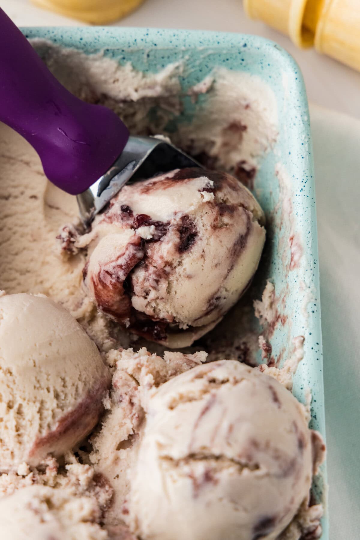 scooping out jam ice cream with blackberry swirl