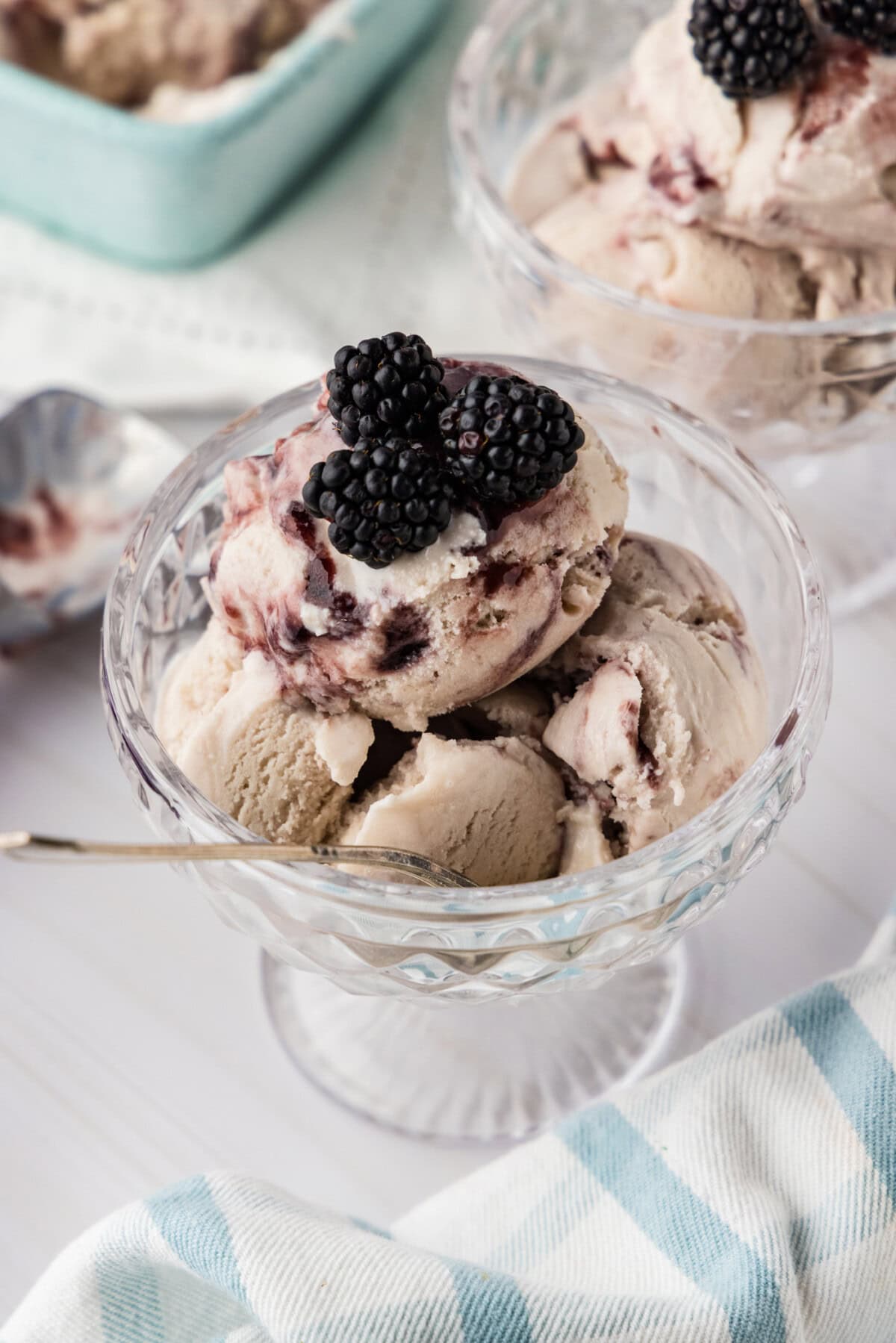 two dishes of jam ice cream garnished with blackberries