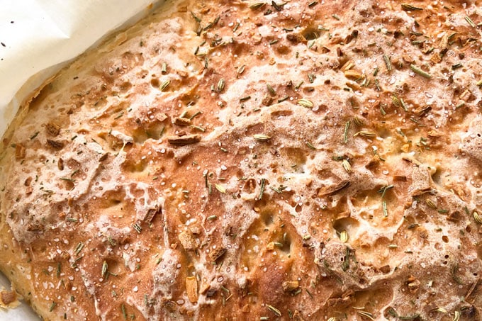 close up of baked bread in a pan sprinkled with herbs and spices