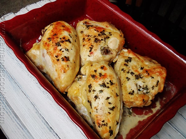 A photo of golden roasted chicken breasts in a red roasting pan.