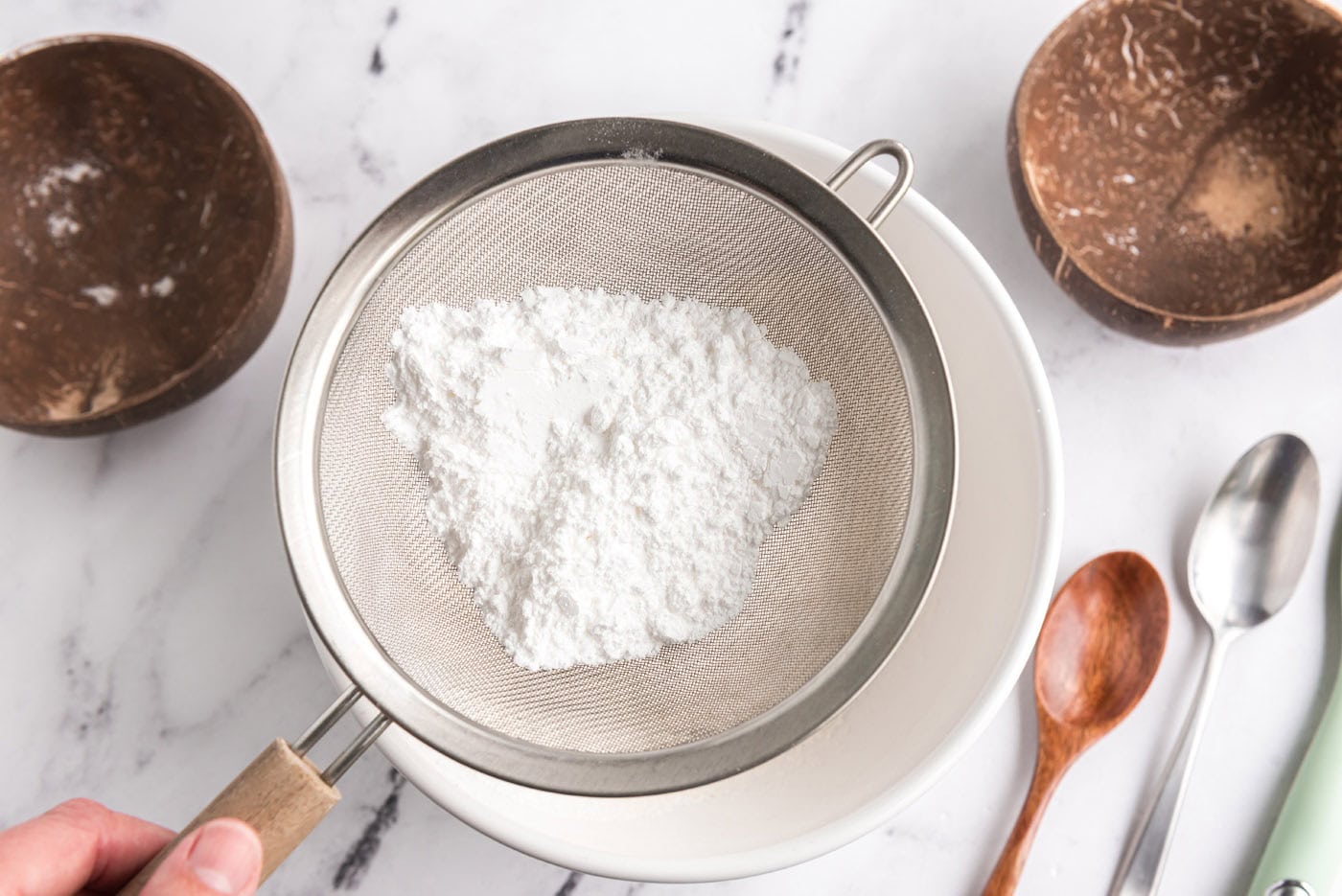 sifting powdered sugar and flour into bowl