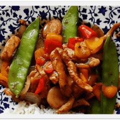 A close up photo of a plate of peppered pork stir fry with sweet peppers.