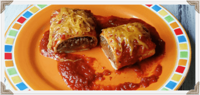 A close up photo of a Taco Bell enchirito copycat cut in half resting on a plate.