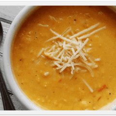 A close up photo of a bowl of creamy white cheddar corn soup.
