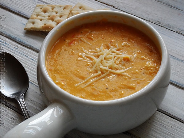 A close up photo of a bowl of creamy white cheddar corn soup.