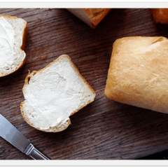 A close up photo of two buttered slices of Amish white bread.