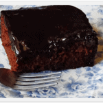 A close up photo of a serving of chocolate prune cake resting on a plate.