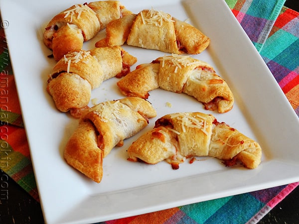 An overhead photo of pizza crescent roll ups on a white platter.