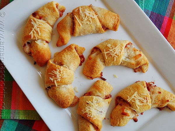 An overhead photo of pizza crescent roll ups on a white platter.