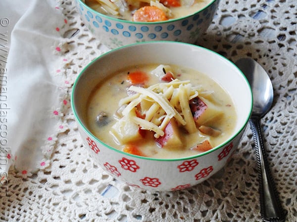 A close up photo of rustic garlic potato soup in a bowl.