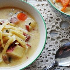 A close up photo of rustic garlic potato soup in a bowl.