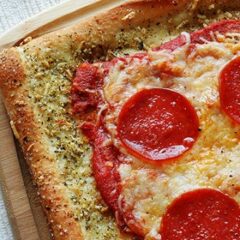 A close up photo of garlic bread crusted classic pizza.