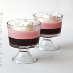 A photo of two creamy raspberry Jell-O parfaits.