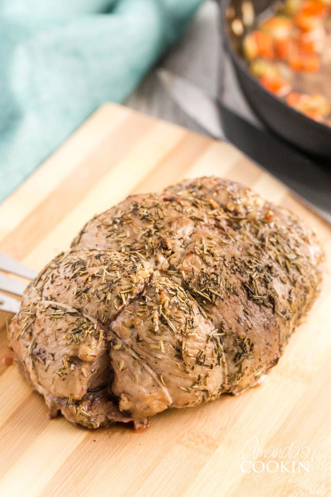 cooked pork roast on a wooden cutting board