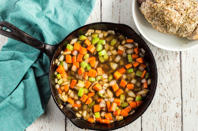 sauteed onions celery and carrots in a pan