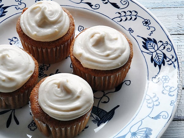 A close up photo of four time saver carrot cupcakes on a plate.