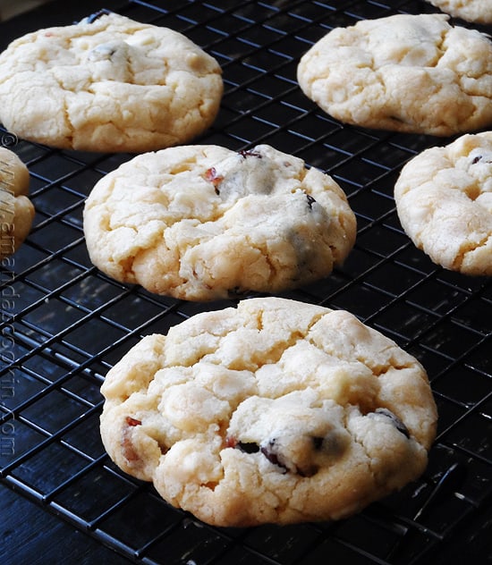 A close up photo of cherry white chocolate chip cookies on a cooling rack.
