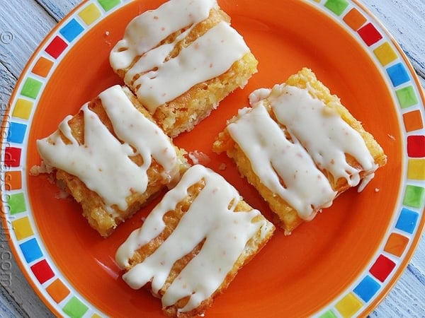 A close up overhead photo of tropical dream dessert bars on an orange plate.