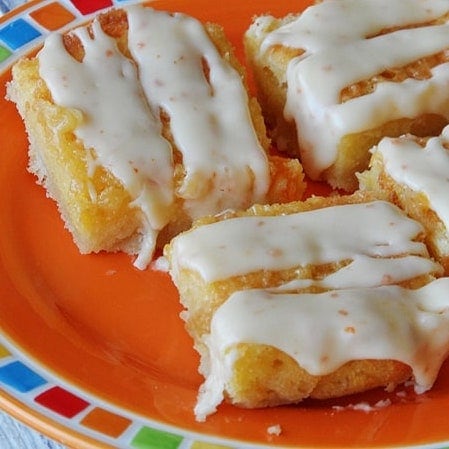 A close up photo of tropical dream dessert bars on an orange plate.