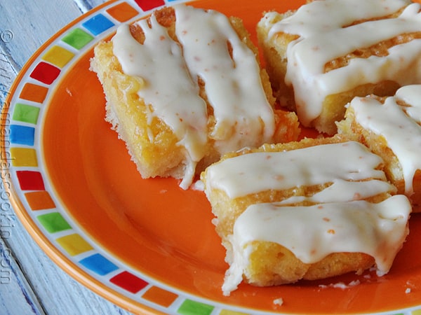 A close up photo of tropical dream dessert bars on an orange plate.