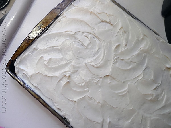 An overhead photo of a sheet pan of banana bars with vanilla cream cheese frosting.