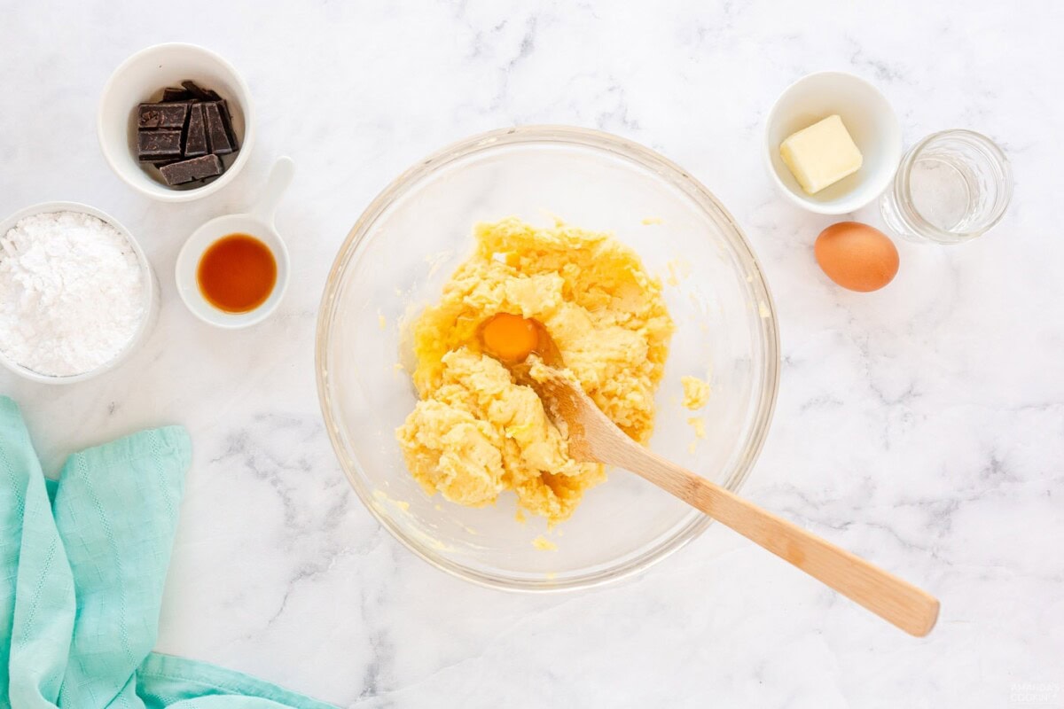 mixing dough with wooden spoon in a bowl
