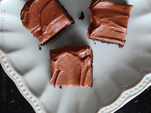 An overhead photo of fudge frosted espresso brownies on a white plate.