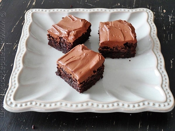 A photo of fudge frosted espresso brownies on a white platter.