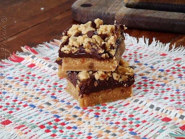 Two peanut butter chocolate layer bars stacked on top of each other. 