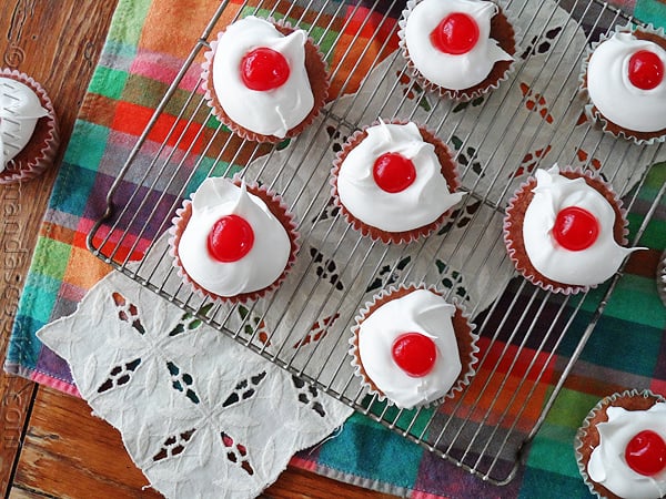 An overhead photo of cherry cupcakes on a cooling rack.