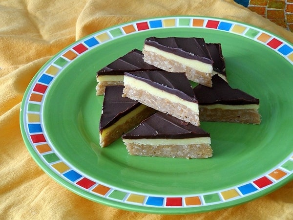 A close up photo of no bake peanut butter pudding bars resting on a green plate.