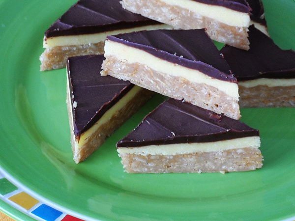 A close up photo of no bake peanut butter pudding bars resting on a green plate.