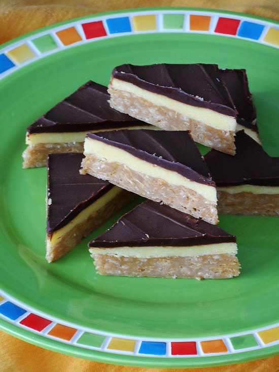 A close up photo of no bake peanut butter pudding bars resting on a green plate.