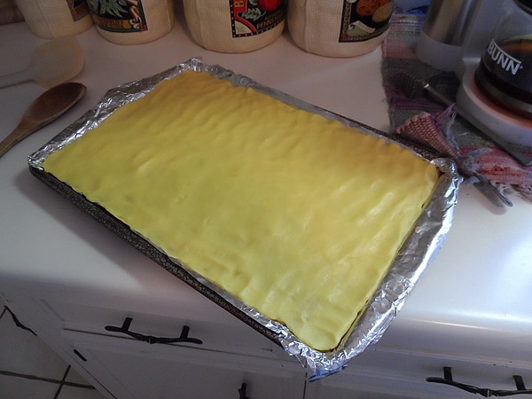 A photo of the pudding mixture over the cereal layer in the lined pan.