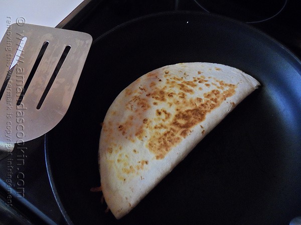 An overhead photo of a beef and bean quesadilla in a skillet.