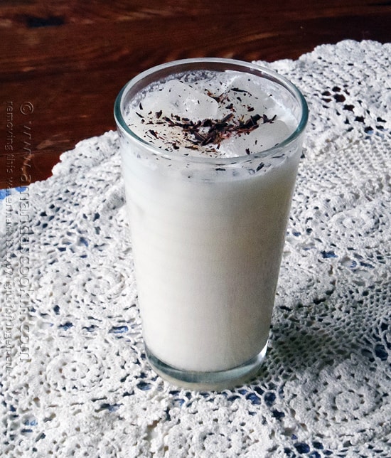 A photo of a tall clear glass filled with an Olive Garden Italian cream soda with chocolate shavings on top.