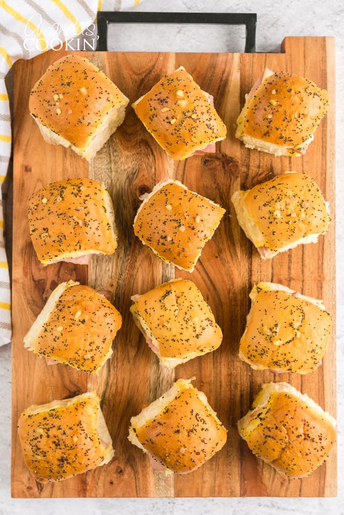 multiple ham and cheese sliders on a cutting board