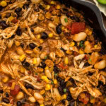 Close up of chicken chili with black beans, cannellini beans, corn and diced tomatoes in a cast iron skillet