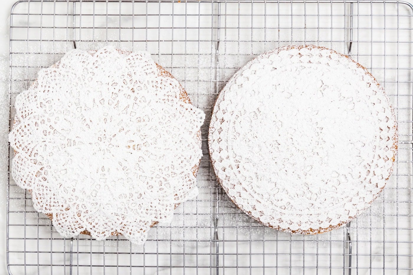 doilies on top of cake and dusted with powdered sugar