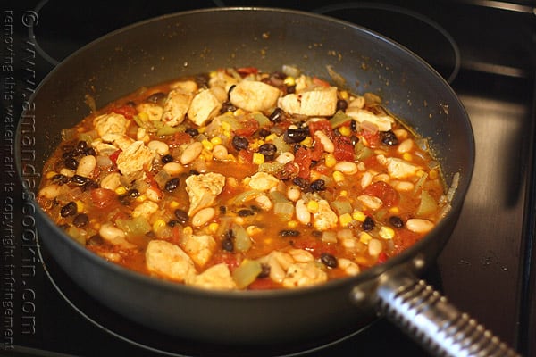 A close up photo of chicken chili with black beans and corn in a skillet.